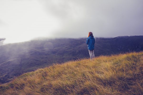 Woman admiring sunset from mountain top Woman admiring sunset from mountain top